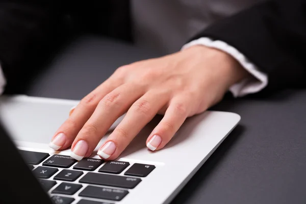 Office woman is holding hand on the laptop keyboard