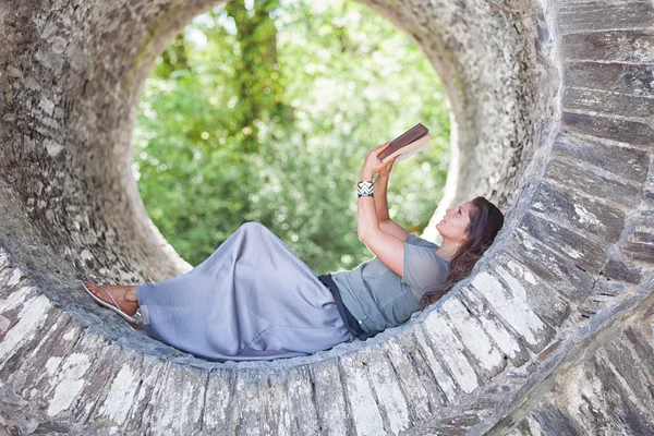 Relaxing lady reading her book outside.