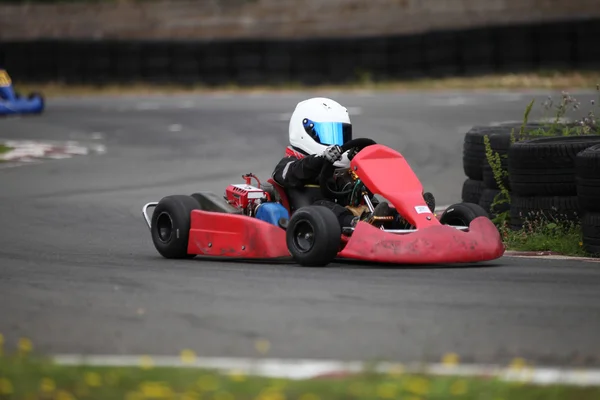 Young child racing a go kart on a race circuit track