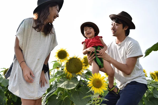 Young family is smiling with sunflower field