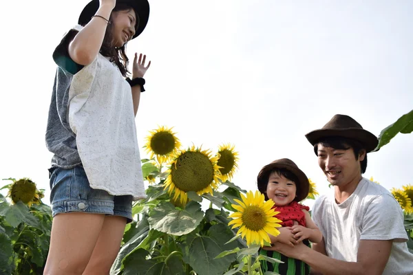 Young family is smiling with sunflower field