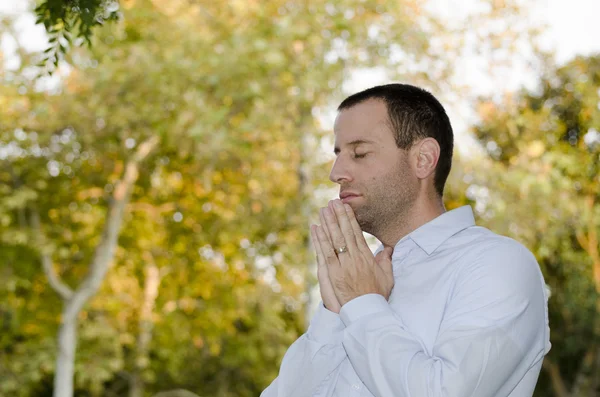 Man praying on a fall/autumn day.