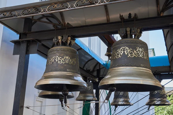 Bells with a beautiful ornament. Bells hung on a metal beam