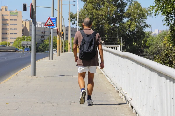 Sporty man walking over a bridge