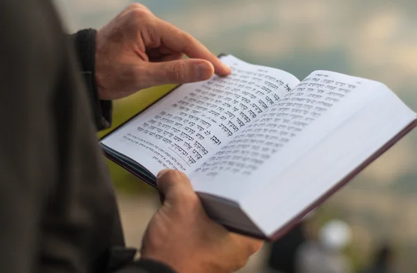 Man holding Mahzor. Hands holding book