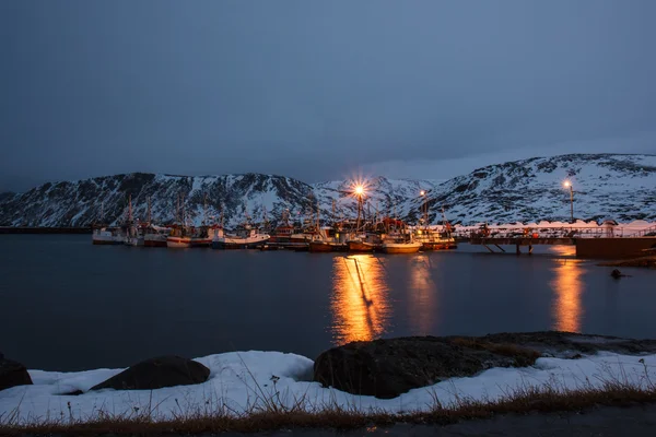 Bay with boats during polar night close to the Nord Cape at Skarsvg, Norway
