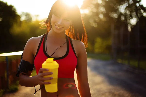 Young fitness woman outdoor with protein shake