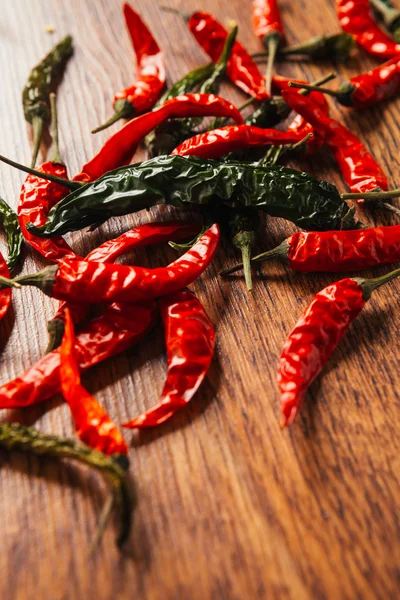 Green pepper and Red peppers on wooden table