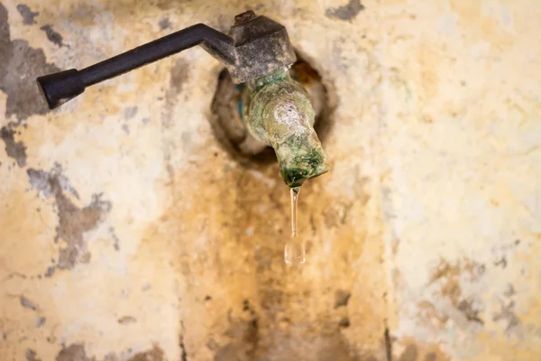 Old rusty tap leaking water