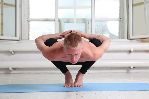 Man practicing yoga. Sitting in squat, Garland pose, Malasana