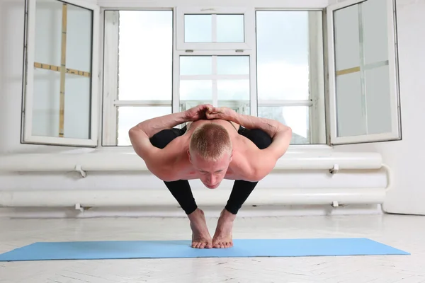 Man practicing yoga. Sitting in squat, Garland pose, Malasana