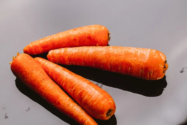 Fresh raw carrots on a black background