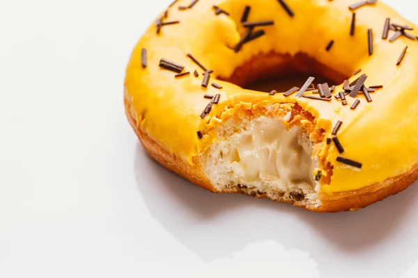 Bitten donut with banana cream on a white background