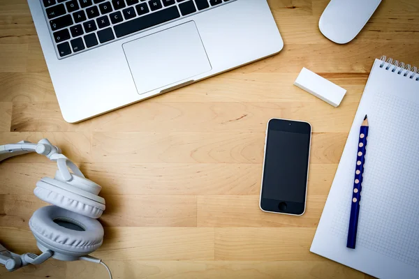 Desk, computer, paper, phone on a wooden desk