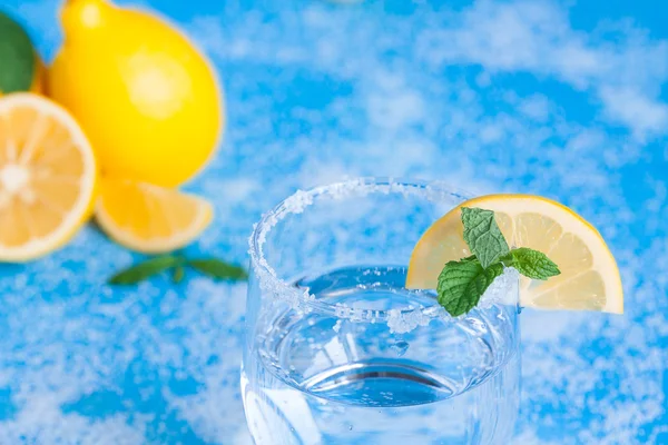 Glass of lemonade on the blue wood table with mint and sugar