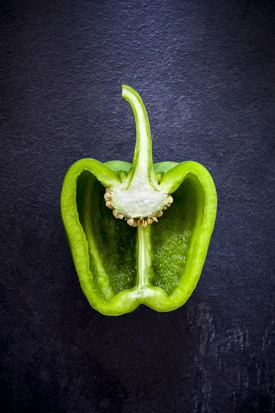 Cross section of a green bell pepper on dark bacground