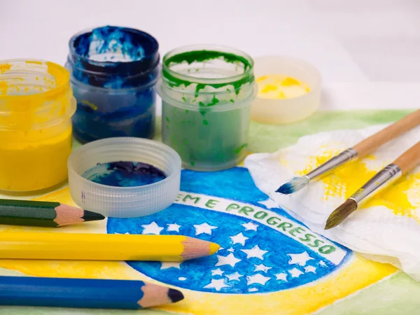 Paints,brushes and color pencils on the brazil flag watercolor