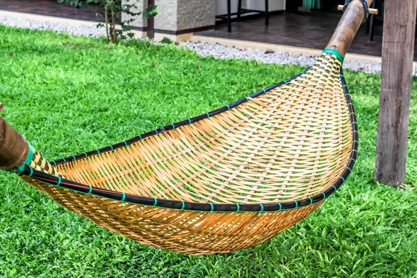 Hanging bench seat chair cradle hammock in basket design on the green grass field