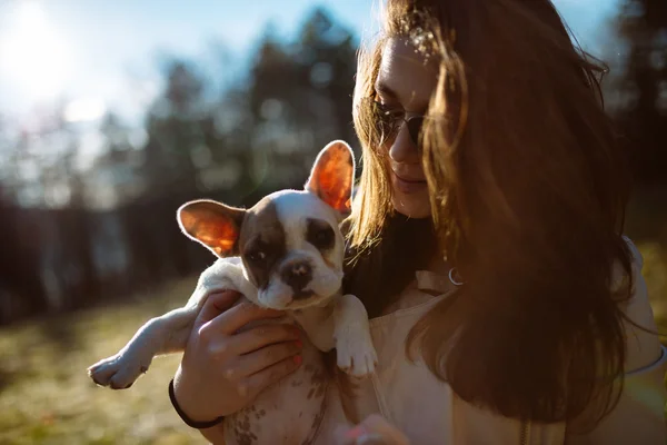 Girl in sunglasses playing with puppy