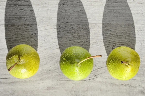 Three juicy green pear with water drops