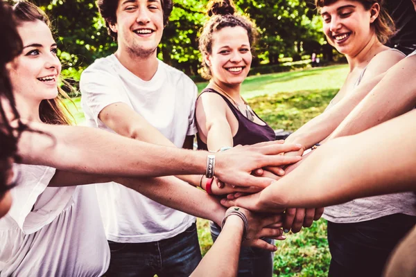 Happy friends holding hands together