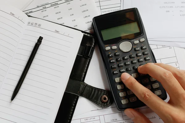 Savings, finances, economy and office concept - close up of man with calculator counting making notes, pen on the note book and bill at desk office, data analysis, soft focus.