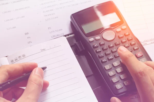 Close-up of Human accountant making calculations while sitting at desk in office, soft focus