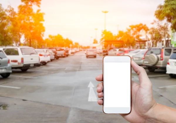 Smart phone showing blank screen in man hand with blur cars parking