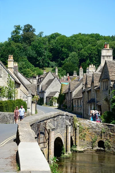 Stone bridge over the river Bybrook with cottages to the rear, Castle Combe.