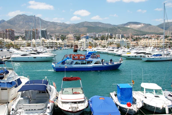 Yachts moored in the marina with buildings and mountains to the rear, Benalmadena.