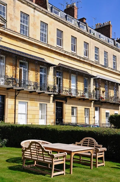 Wooden table and chairs outside the Royal Mews Georgian houses in Suffolk Square, Cheltenham.