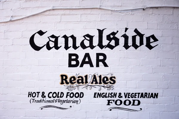 Canalside bar sign painted on a brick wall in Gas Street Basin, Birmingham.