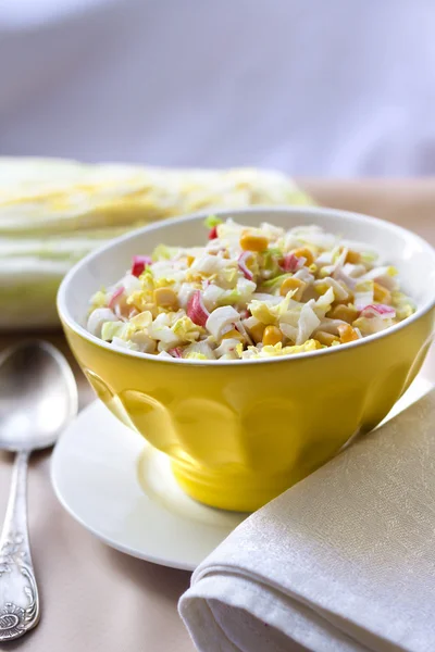 Chinese cabbage, sweet corn and surimi salad in a yellow bowl