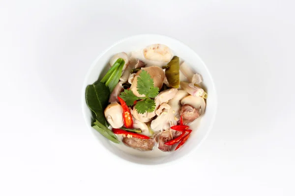 Chicken and galangal in coconut milk soup and herb on white background