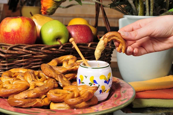 Closeup of a hand dipping pretzel in mustard sauce