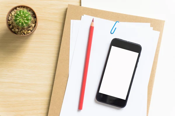 Blank paper, pencil, and smart phone on wood desk.