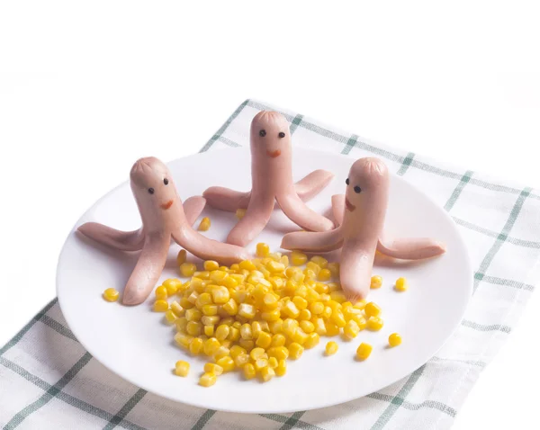 Food for children. Three funny octopus made of sausages on a pla