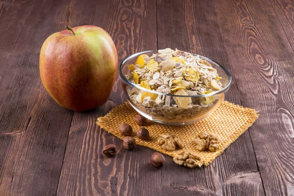 Bowl of muesli, apple, nuts, flakes, candied  for a nutritious