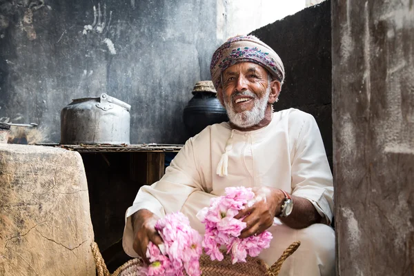 Omani man holding rose petals
