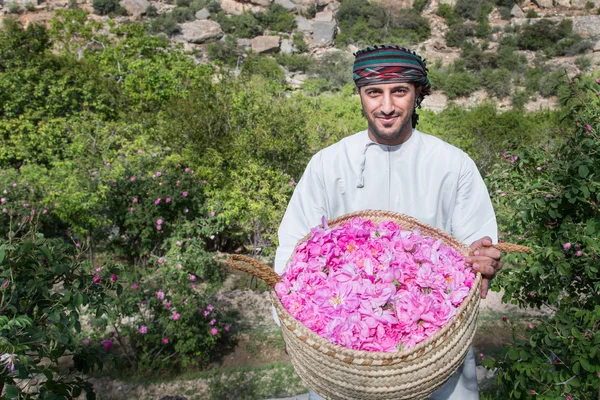 Man is showing off basket full of roses