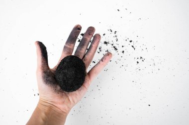 Kül içinde eski bir ördek yumurtası tarifi. Beyaz arka planda kül içinde tuzlu ördek yumurtası. Bir yumurtayla küle bulanmış bir el.