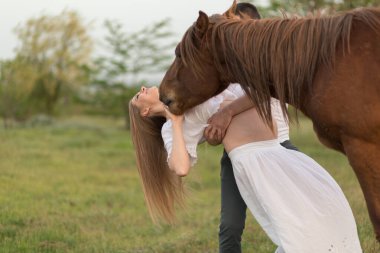 Çiftliğinde gün batımında hamile karısı olan bir çiftçi. Atla poz vermek..