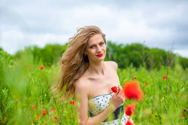 暑い夏の日に咲くポピー畑で自然の色を楽しむ若い長髪の女の子 — ストック写真