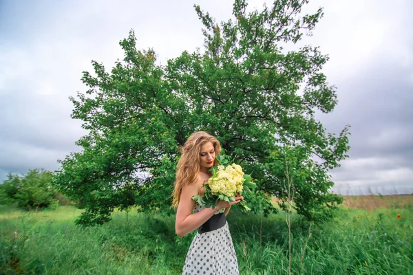 美しい若いブロンドの女の子が野の花の花束を集めました 暖かい夏の日に散歩をお楽しみください — ストック写真