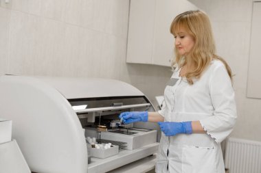 Laboratuvar teknisyeni kan örneğini otomatik olarak analiz ediyor..