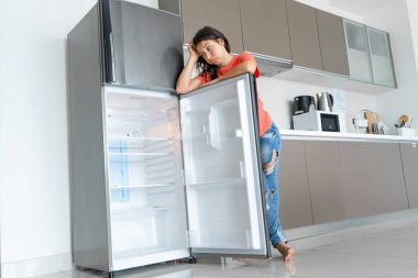 Kız boş buzdolabına şaşırdı. Yiyecek eksikliği. Yemek teslimatı.