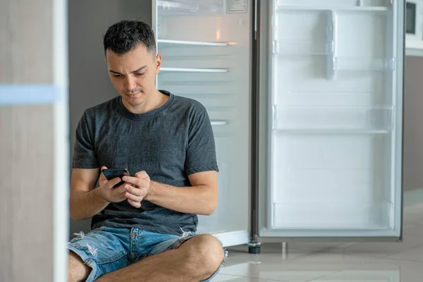 Jovem Pede Comida Usando Smartphone Frigorífico Vazio Sem Comida Serviço — Fotografia de Stock