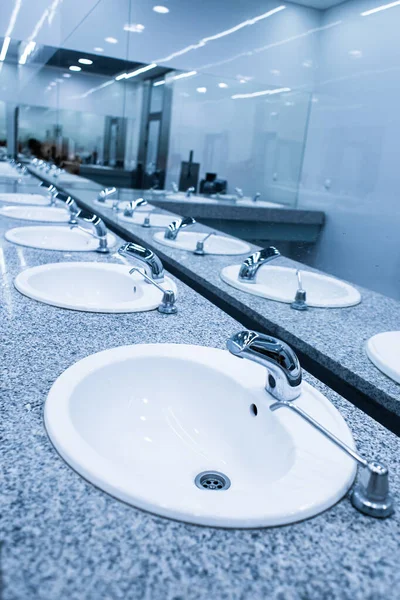 スタイリッシュなモダンな公衆トイレ 大きな鏡の前に洗面台の列 — ストック写真