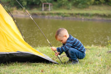 Çadırdaki küçük çocuk. Doğada kamp yapmak.