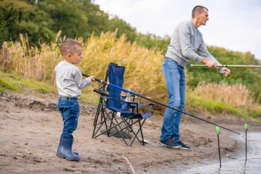 Mutlu bir aile birlikte vakit geçirir. Oğullarına balık tutmayı öğretirler.